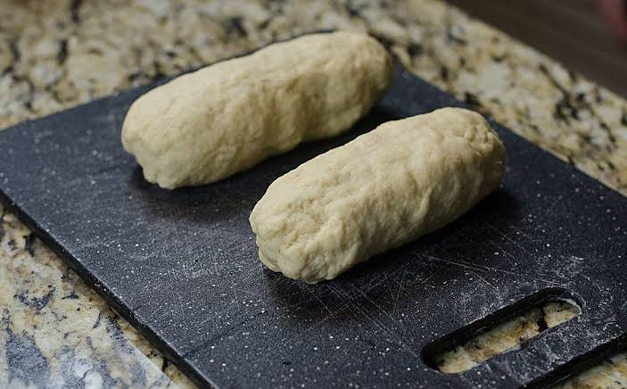 Bread mixture being rolled into small dumplings.